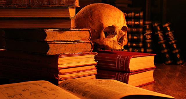 stacks of old books and a skull