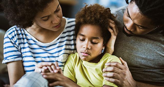 Adults comforting a worried child.